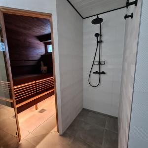 a walk in shower in a bathroom with a glass door at Iso-Syöte Villa Remo in Syöte