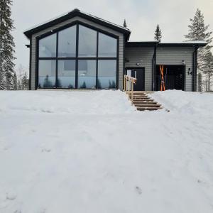 a house in the snow in front at Iso-Syöte Villa Remo in Syöte