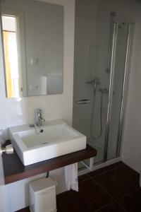 bagno bianco con lavandino e doccia di Apartamentos Parque Mar a Cala d´Or