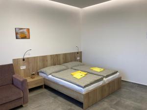 New Pension at ROTOR Brewery في Kunowitz: غرفة نوم بها سرير مع مجلدين صفراء عليها