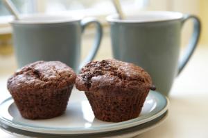 deux muffins sur un plat avec deux tasses de café dans l'établissement Lowthwaite B&B, à Watermillock