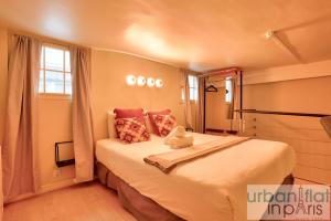 a bedroom with a large white bed with a window at 33 - Flat Av des Champs-Élysées in Paris