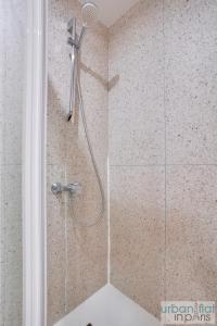 a shower with a shower head in a bathroom at 33 - Flat Av des Champs-Élysées in Paris
