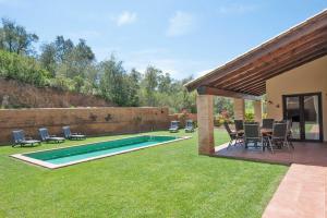 una piscina in un cortile con sedie e un patio di Mooie 6P villa met privézwembad, grote tuin en gratis WiFi in Begur a Begur