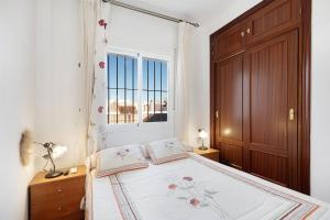 een slaapkamer met een groot bed en een raam bij Villa Maria in Chipiona