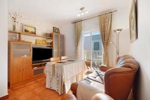 een woonkamer met een bank, een tv en een tafel bij Villa Maria in Chipiona