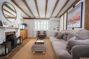 a living room with a couch and a fireplace at Dragonfly Cottage, Long Melford in Long Melford