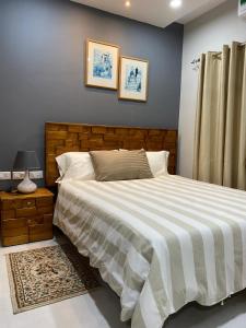 1 dormitorio con 1 cama grande y cabecero de madera en Aquaview Apartments, en Bijilo