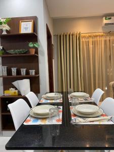 un comedor con una mesa con platos y sillas en Aquaview Apartments, en Bijilo