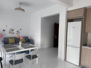 a kitchen with a table and a white refrigerator at Pireas new hotel in Piraeus