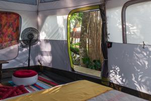 una camera con letto e finestra in una tenda di Glamping Coco Dendê - Algodões a Praia dos Algodões