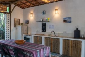 a kitchen with a counter with a sink and a refrigerator at Glamping Coco Dendê - Algodões in Praia dos Algodões