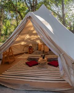 a canvas tent with a bed and a table at Glamping Coco Dendê - Algodões in Praia dos Algodões