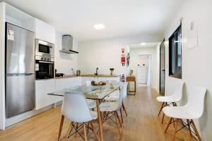 Vila BaleiraにあるCasa Fonte São Joãoのキッチン、ダイニングルーム(テーブル、白い椅子付)