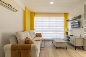 ein Wohnzimmer mit einem Sofa und einem Tisch in der Unterkunft Comfy Residence Flat 3 min to Mall of Antalya in Antalya