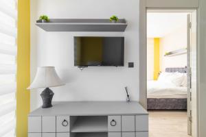 ein Wohnzimmer mit einem TV und einem Tisch mit einer Lampe in der Unterkunft Comfy Residence Flat 3 min to Mall of Antalya in Antalya
