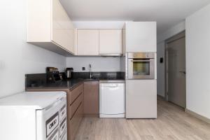 cocina blanca con electrodomésticos blancos y suelo de madera en Comfy Residence Flat 3 min to Mall of Antalya, en Antalya
