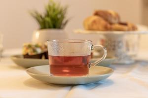 eine Tasse Tee auf einem Teller auf einem Tisch in der Unterkunft Liberty suite in Bassano del Grappa