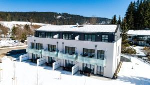 an aerial view of a white building in the snow at Braviscasa - Ferienresidenz Bärenhof Titisee in Titisee-Neustadt