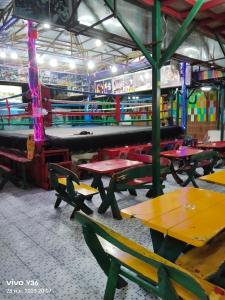 ein Zimmer mit Tischen und Bänken in einem Gebäude in der Unterkunft Reggaeinn in Ko Phi Phi