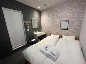 a bedroom with a white bed and a sink at COB HOTEL Asakusa in Tokyo