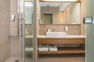 a bathroom with a sink and a mirror at Cosmopolitan Hotel & Spa in Paralia Katerinis