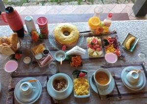 una mesa con comida para el desayuno y bebidas en ella en Chalé Silvia Gatto - Suíte Bauru en Núcleo Mauá