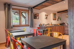 a restaurant with tables and chairs and a kitchen at Chalet CHARMING B AND B in Les Gets