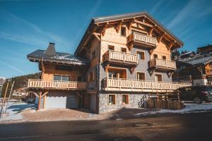 a large wooden house with balconies on the side of it at Chalet CHARMING B AND B in Les Gets