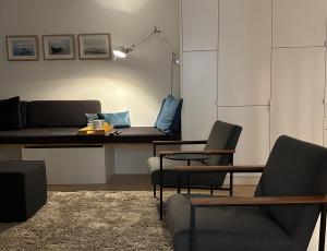 a living room with a couch and a table and chairs at Inselloft Rügen - Meerblick, Pool & eigener Strandzugang in Binz