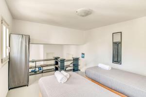 1 dormitorio con 2 camas y ventana en Sand And Seas: Villa Asterias, en Ampelas