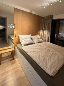 a bedroom with a large bed with a wooden headboard at Inselloft Rügen - Meerblick, Pool & eigener Strandzugang in Binz