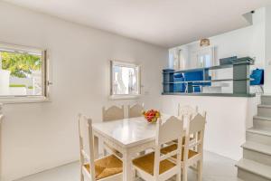 un comedor blanco con una mesa y sillas blancas en Sand And Seas: Villa Asterias, en Ampelas