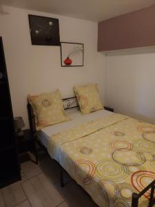 a bedroom with a bed with yellow sheets and pillows at Studio loué entier proche de Paris in Ecquevilly
