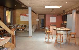cocina y sala de estar con mesa y sillas en Chalet Le Petit Bes by Leavetown Vacations en Les Deux Alpes