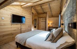 1 dormitorio con 1 cama y TV de pantalla plana en Chalet Le Petit Bes by Leavetown Vacations en Les Deux Alpes