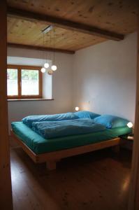 a bedroom with a large bed with blue pillows at Chasa Pro La Tuor Pitschna in Ardez