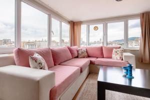 a pink couch in a living room with windows at Flat 7 min to Coast in Suadiye in Istanbul