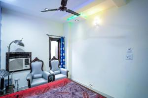 uma sala de estar com 2 cadeiras e uma ventoinha de tecto em Pacific Grand em Amritsar