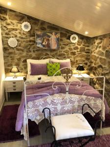 Tarouca的住宿－Casas do Lobo，一间卧室设有一张床和石墙