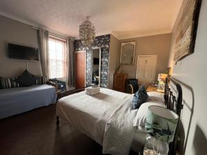a bedroom with a large white bed in a room at Kelston Guest House in Weymouth