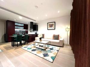 a living room with a couch and a table at CENTRAL LONDON STAY-Fabulous Ultra-Central London Luxury Designer One Bedroom Flat with inner garden view balcony AC and kitchen in London