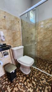 een badkamer met een toilet en een glazen douche bij Suítes Green Village Flecheiras in Flecheiras