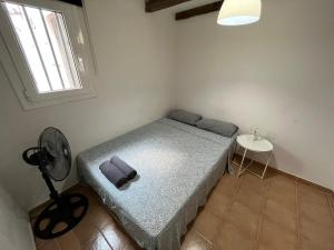 a small bedroom with a bed and a fan at Large Apartment in el Raval in Barcelona