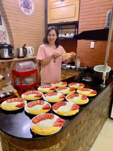 Uma mulher numa cozinha com pratos de comida. em Lan’s home em Cao Bang