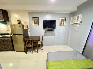 uma pequena cozinha com uma mesa e um frigorífico em CebuSureStay Persimmon Studio 535 em Cebu
