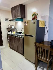 Il comprend une cuisine équipée d'un réfrigérateur en acier inoxydable et d'une table. dans l'établissement CebuSureStay Persimmon Studio 535, à Cebu