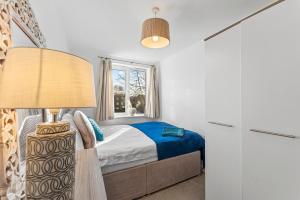 曼徹斯特的住宿－Designer Apartment - Great Location!，一间卧室配有一张床和一盏灯