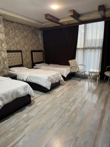 1 Schlafzimmer mit 2 Betten und Holzboden in der Unterkunft Motel Blue Corner in Erbil