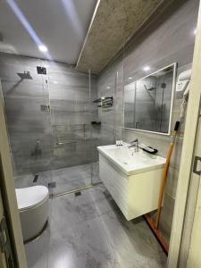 ein Badezimmer mit einem Waschbecken, einem WC und einem Spiegel in der Unterkunft Motel Blue Corner in Erbil